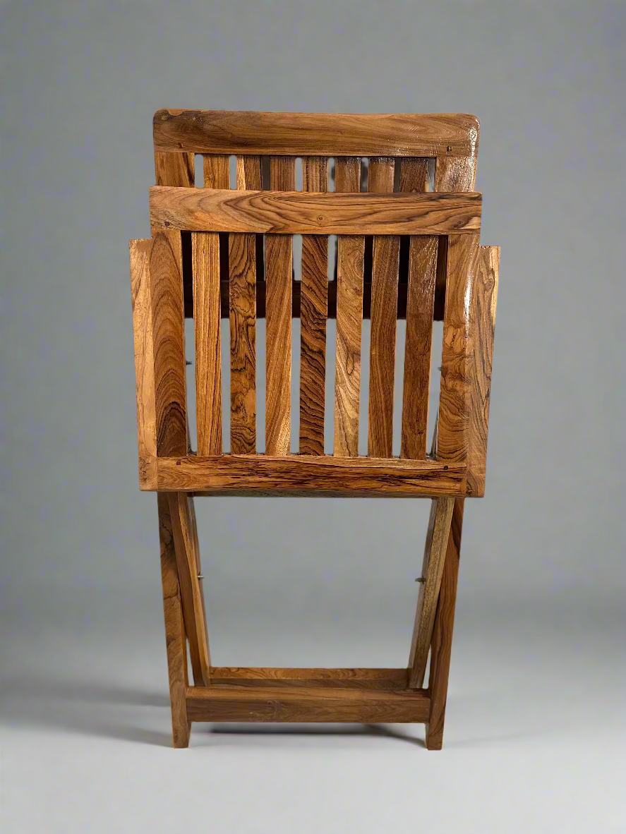 Wooden chair with slatted design on a concrete floor against a gray wall.